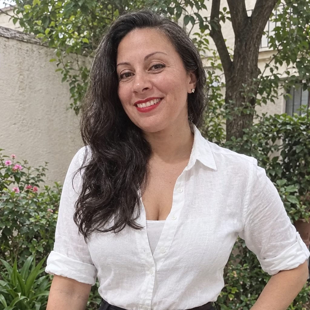 Mariana Medici en un patio, con camisa blanca, sonriendo a cámara