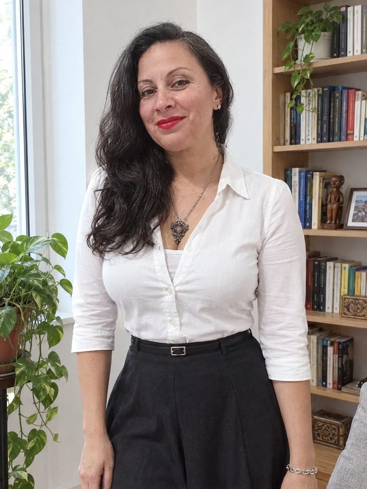Mariana Medici de pie en su casa, con camisa blanca, mirando a cámara